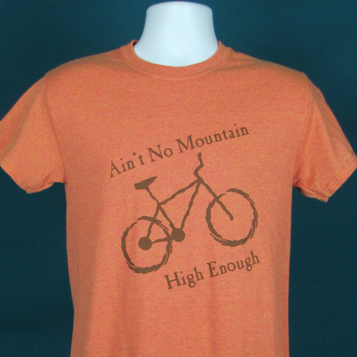 Orange t-shirt with bicycle graphic and text on a mannequin against a dark blue background