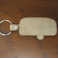 Beige keychain with a metal ring on a wooden surface