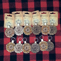 Set of keychains with floral designs on a red and black checkered background