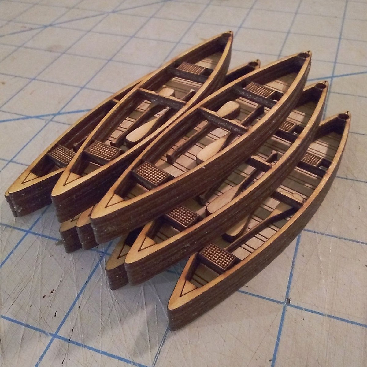Set of wooden model boats on a grid surface