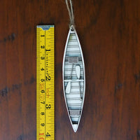 Decorative boat ornament with a ruler for scale on a wooden surface