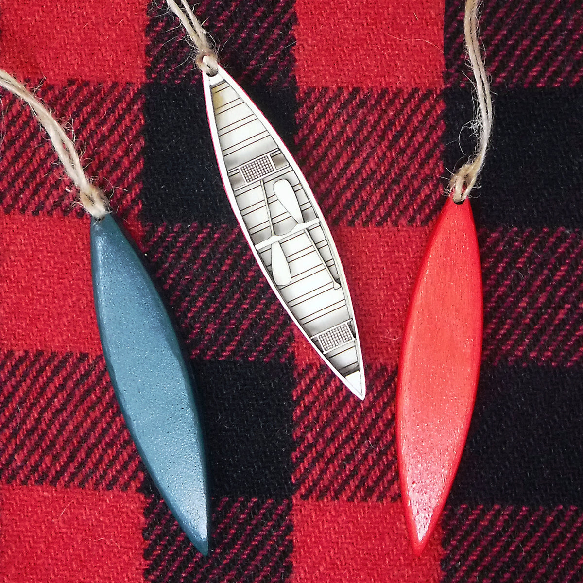 Decorative canoe-shaped ornaments on a red and black plaid background
