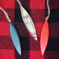 Decorative canoe-shaped ornaments on a red and black plaid background