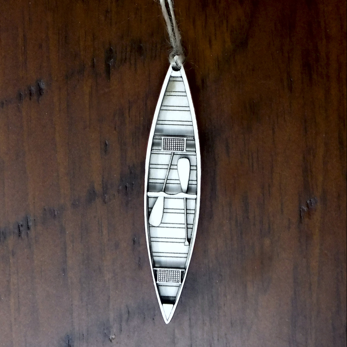 Wood canoe ornament on a wooden background