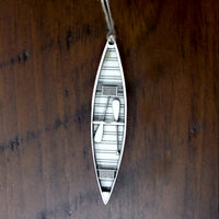 Wood canoe ornament on a wooden background