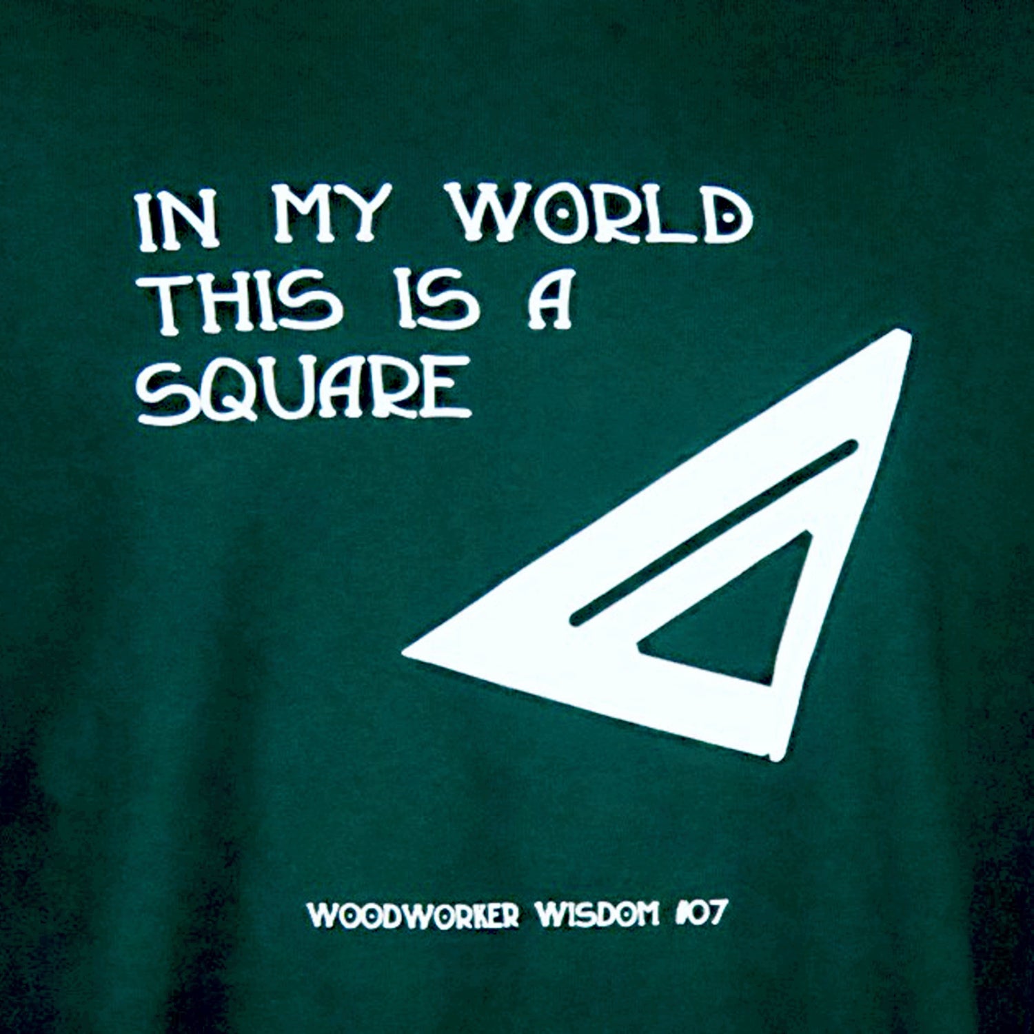 Green t-shirt with white text and triangle design on a dark green background
