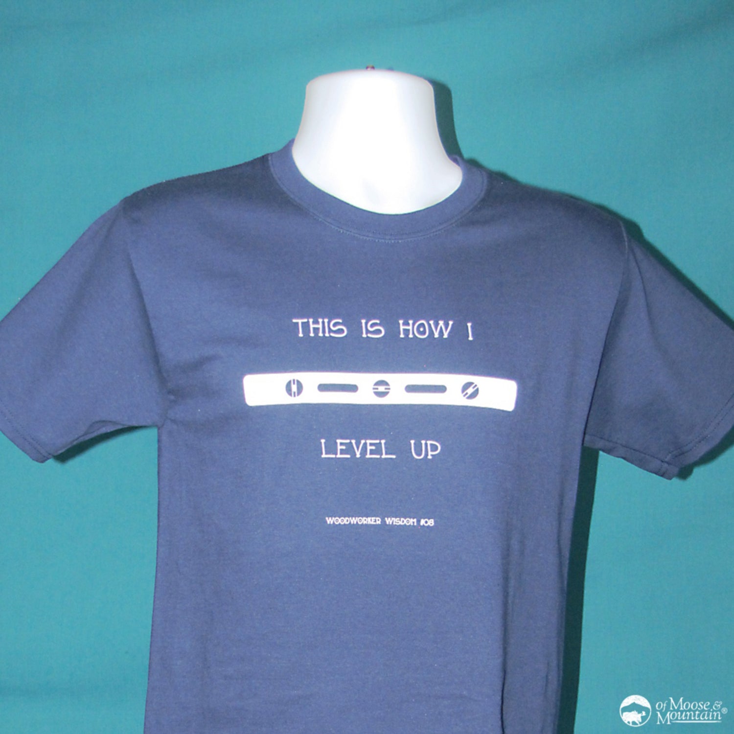 Blue t-shirt with white text and graphic on a turquoise background