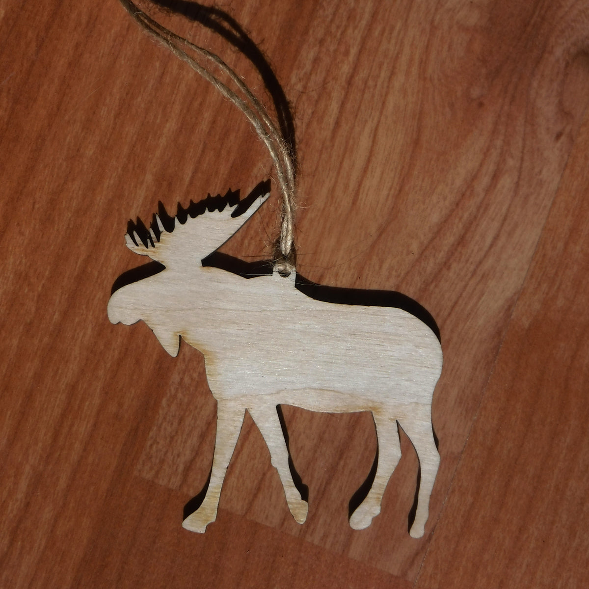 Wooden reindeer ornament on a wooden surface