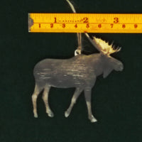 Decorative moose ornament with a ruler for scale on a dark background