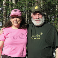 Two people wearing 'Duck Duck Moose' shirts standing in a forest.