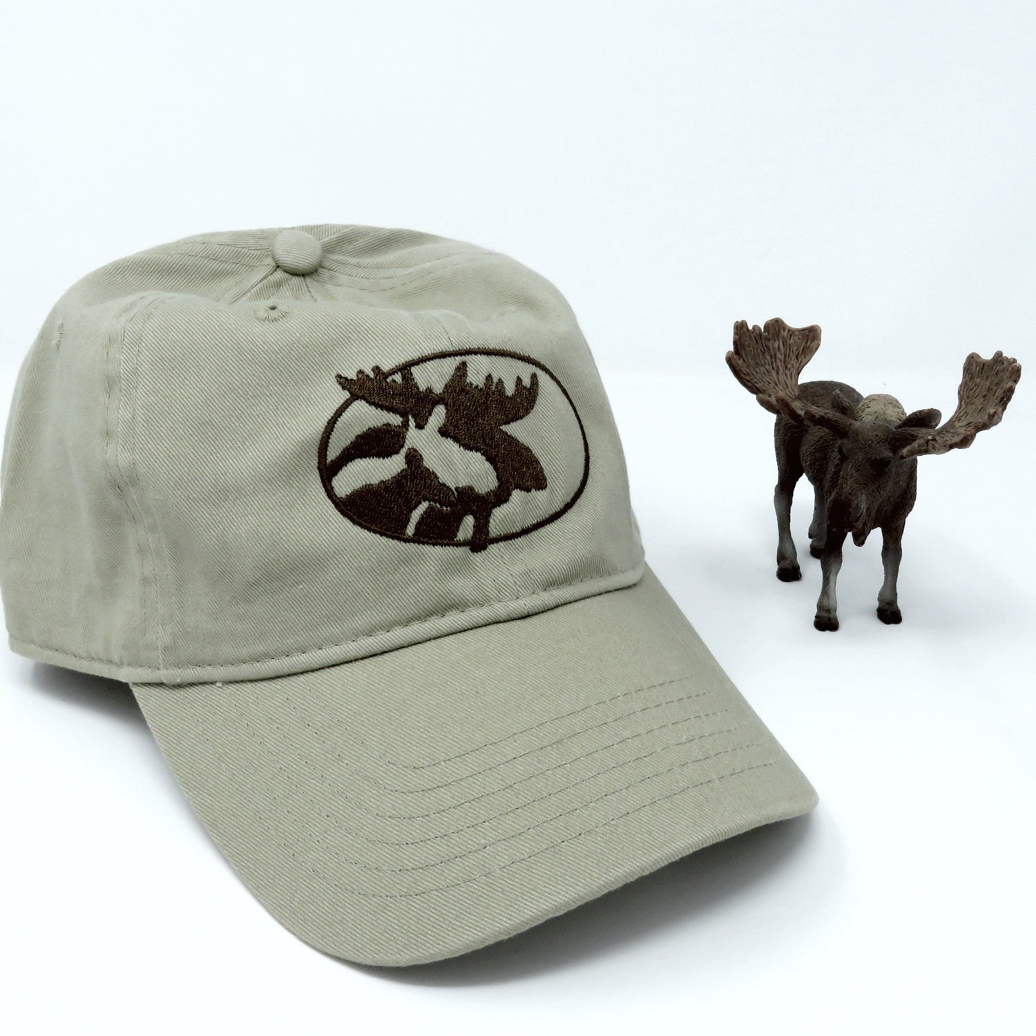 Khaki cap with moose emblem and a small model of a moose on a white background