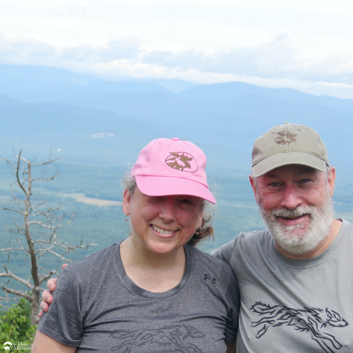 Two people posing together with a scenic mountain view in the background
