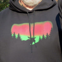 Hoodie with a colorful Northern Lights design of a moose and trees on a dark background
