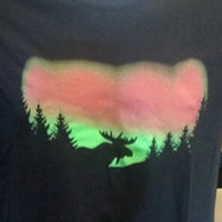 Black shirt with a moose silhouette in front of the featuring pink and green colors of the Northern Lights.