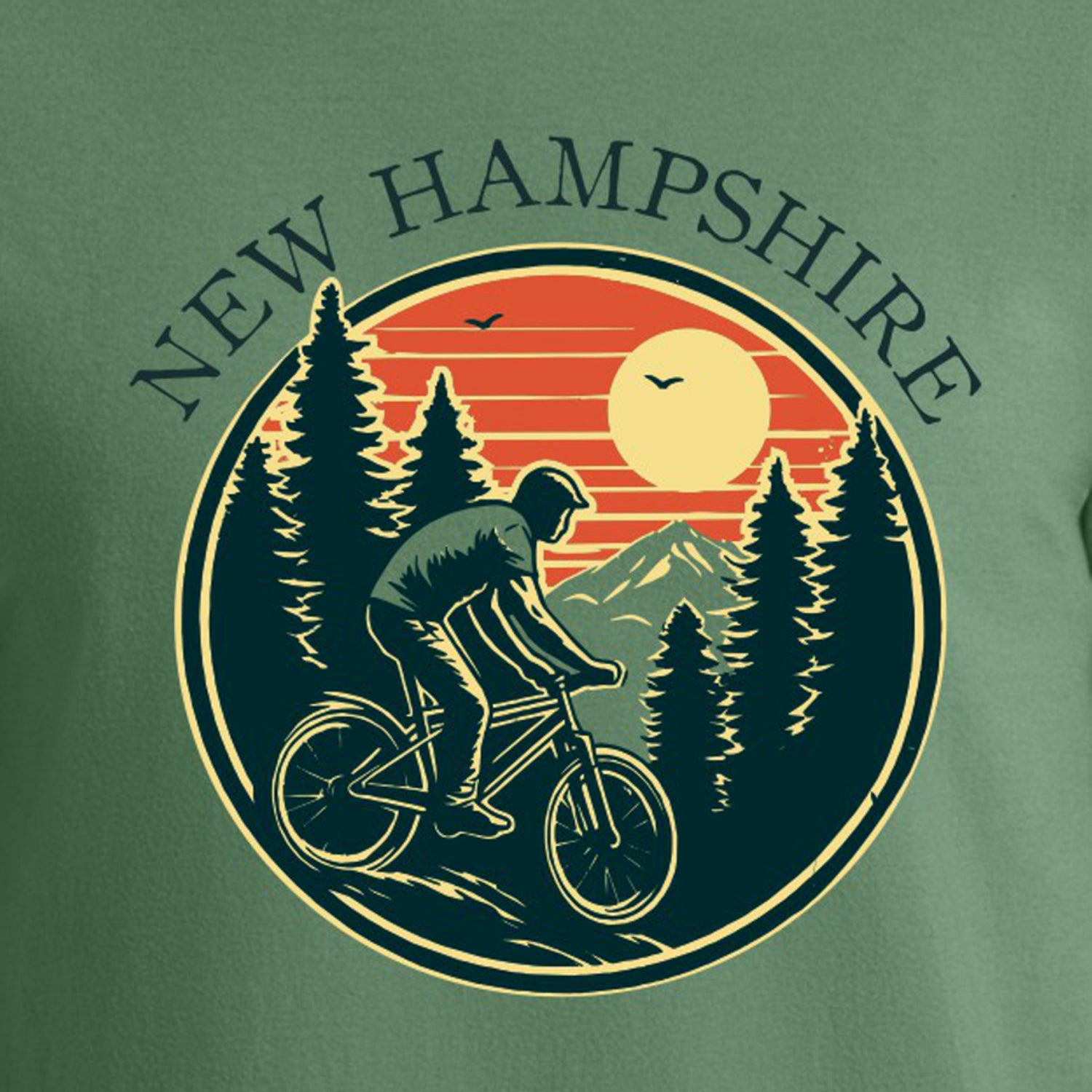 Green t-shirt with a graphic of a cyclist in New Hampshire, featuring trees and a sunset.