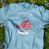 Nordic green t-shirt with a ship graphic and text on grass and flowers