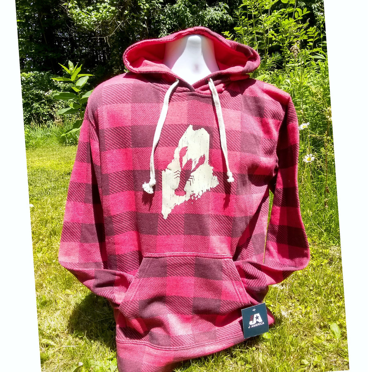 Red and black plaid hoodie with a white Maine lobster logo on a mannequin against a green outdoor background
