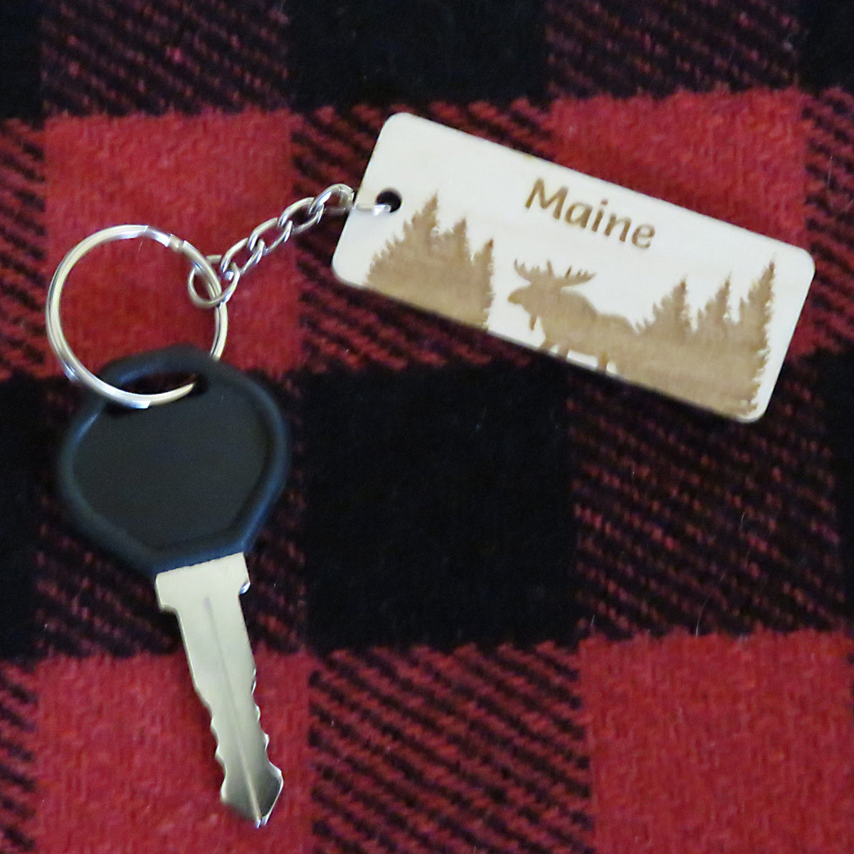 Keychain with 'Maine' tag featuring moose silhouette on red and black plaid fabric