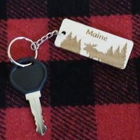 Keychain with 'Maine' tag featuring moose silhouette on red and black plaid fabric