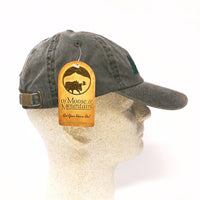 Green cap on a mannequin head with a 'Moose & Mountain' tag.