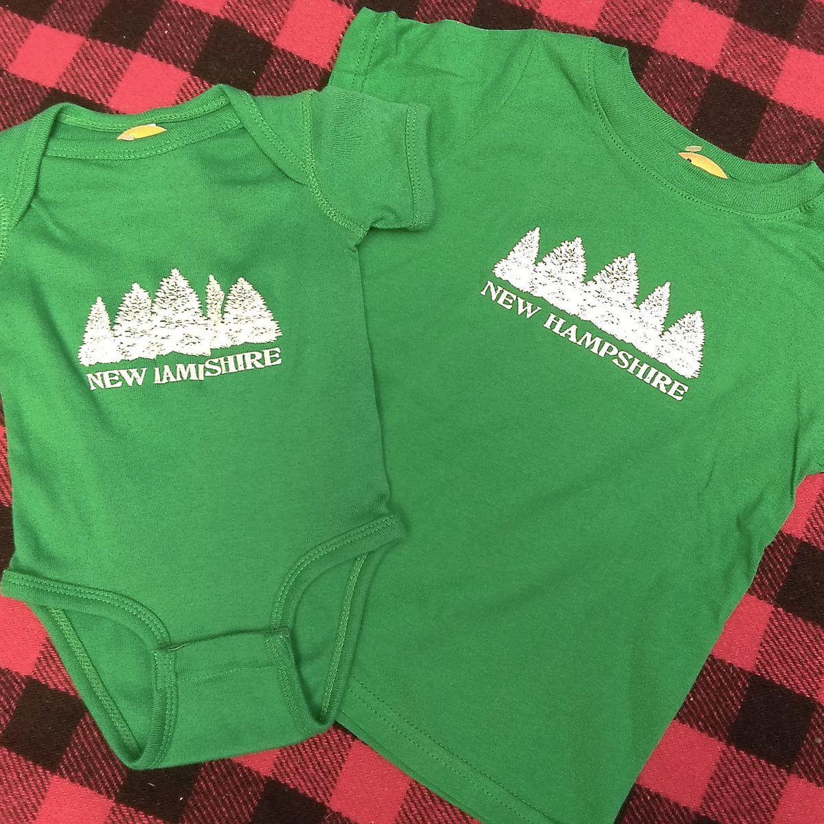 Green shirt and onesie with 'New Hampshire' print on a red and black checkered background