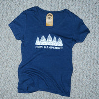 Blue t-shirt with 'New Hampshire' and tree design on a textured surface