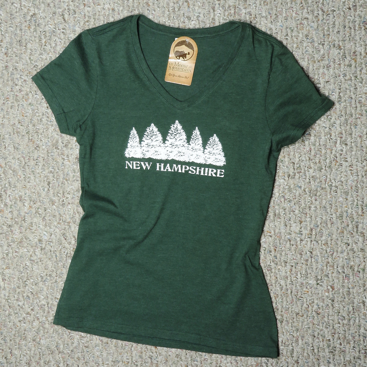 Green t-shirt with white 'New Hampshire' design on a textured surface