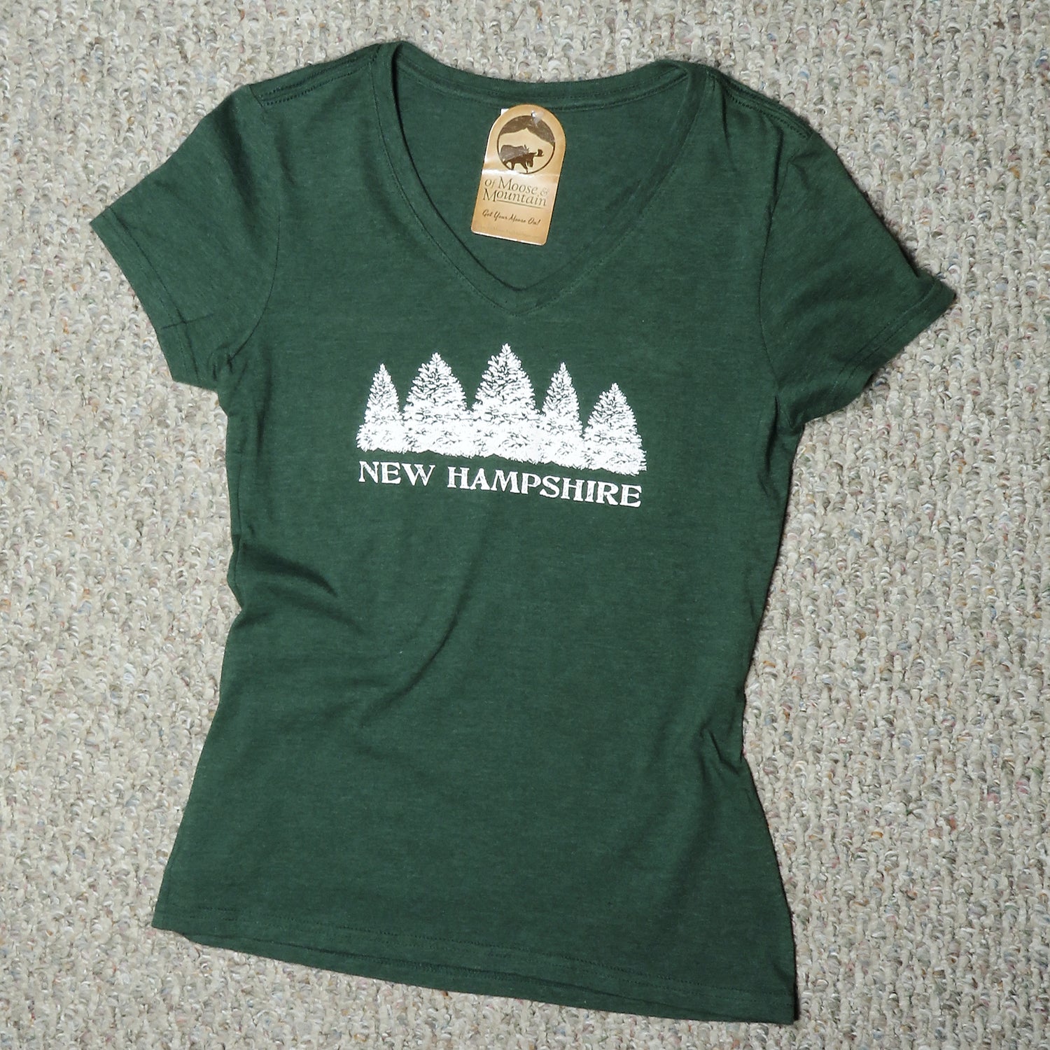 Green t-shirt with white 'New Hampshire' design on a textured surface