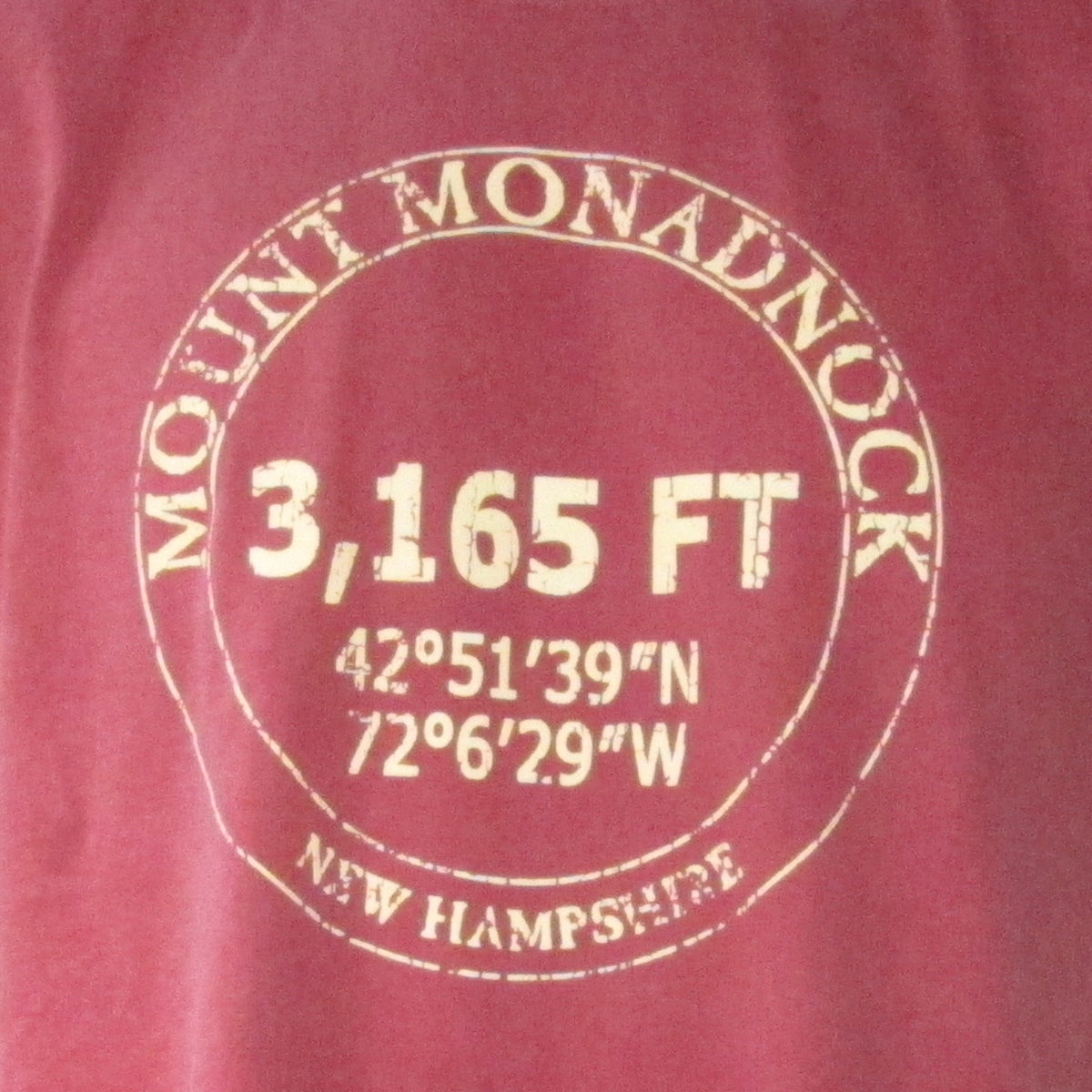 Red shirt with white text detailing Mount Monadnock's elevation and coordinates.