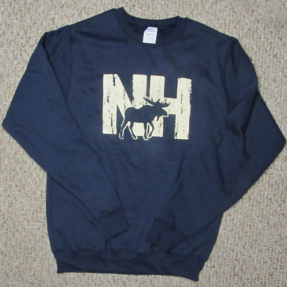 Navy blue sweatshirt with 'NH' and moose graphic on a beige carpet