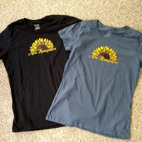 Black and blue t-shirts with sunflower design and 'New Hampshire' text on a beige carpet.