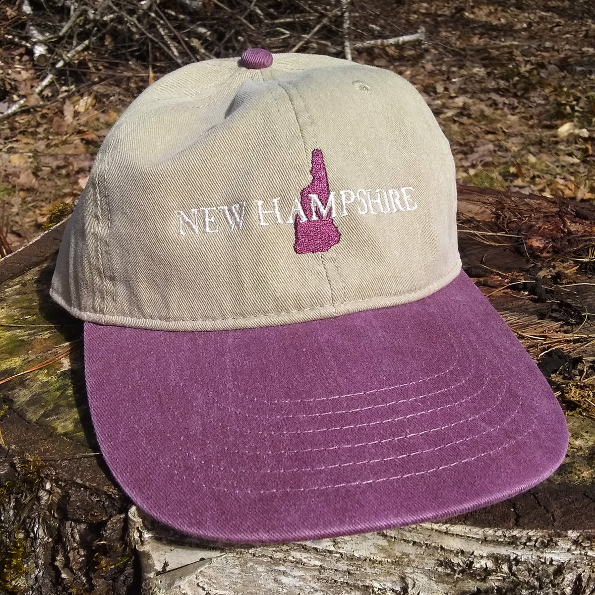 Cap with 'New Hampshire' and state outline on a wooden surface