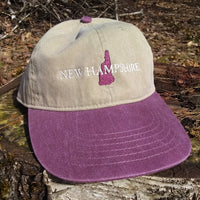 Cap with 'New Hampshire' and state outline on a wooden surface