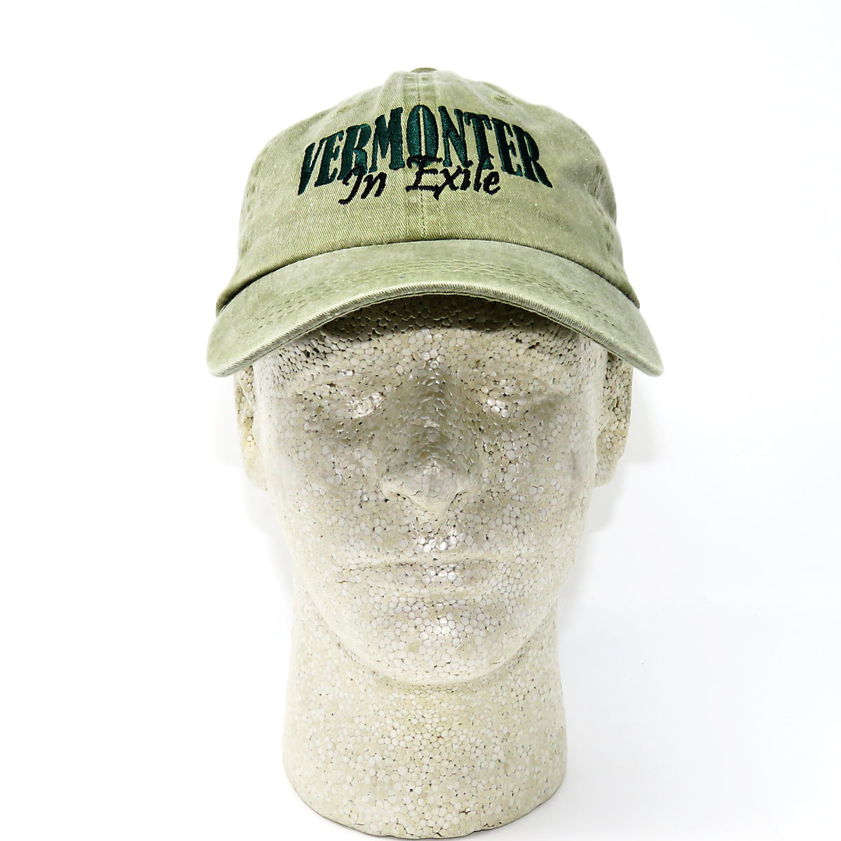 Green cap with 'VERMONTER In Exile' text on a mannequin head against a white background