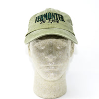 Green cap with 'VERMONTER In Exile' text on a mannequin head against a white background