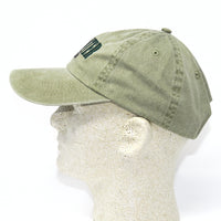 Green baseball cap on a mannequin head with a white background