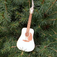 Decorative guitar ornament hanging on a pine tree