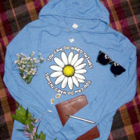 Blue hooded t-shirt with a daisy design and motivational text on a plaid background