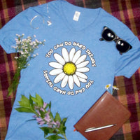 Blue t-shirt with a daisy graphic and "You Can Do Hard Things" text on a plaid background