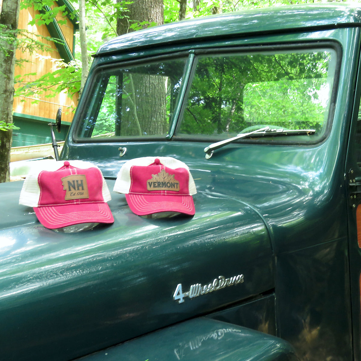 Two red and white caps on a green truck in a forest setting